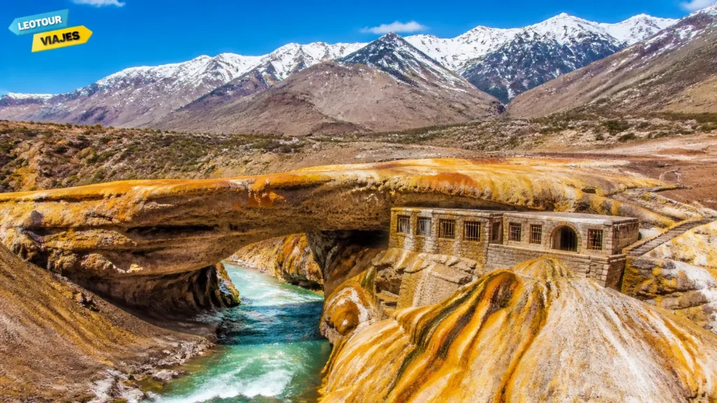 Monumento natural Puente del Inca com rochas minerais e montanhas dos Andes ao fundo na Argentina.